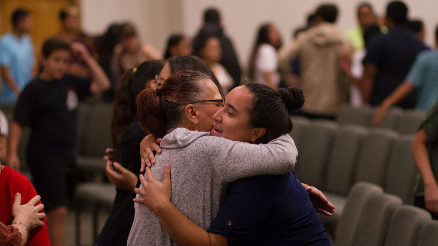 Supportive team leaders hugging a member