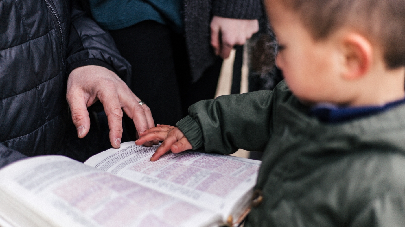Young boy learning to read the bible