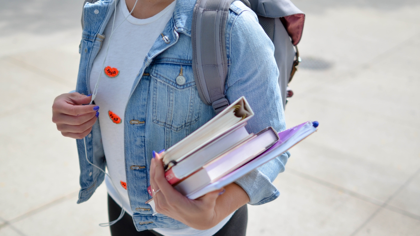 Kid walking to school with backpack and books
