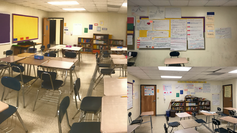An empty classroom. Desks and chairs are set up in rows. The wall is covered in hand drawn posters. A set of cluttered bookshelves are against the wall, with piles of books on top of them.