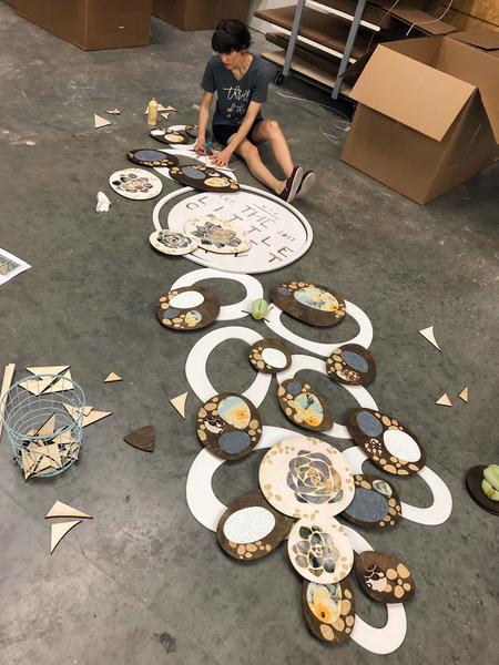 Artist Alyssa Bird assembling the photo backdrop together with wood glue