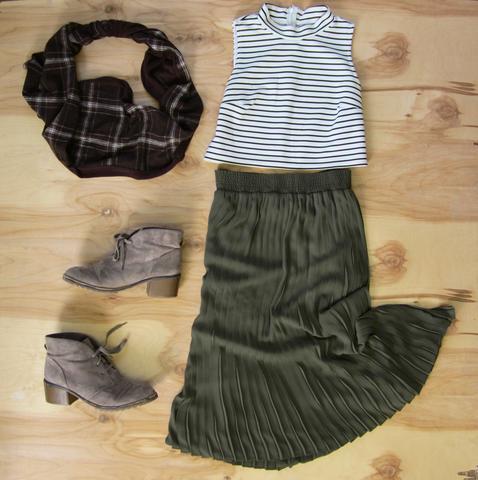 Flat lay: Forest green pleated maxi skirt, black and white plaid crop top, sand colored lace up booties, and Regenerous Designs brown plaid infinity scarf.