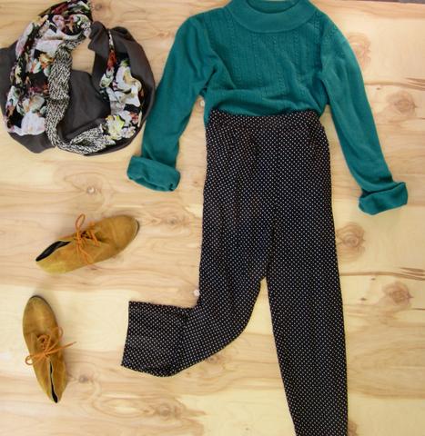 Flat lay: Black and white polkadot pants, teal turtleneck sweater, mustard colored shoes, and Regenerous Designs colorful floral infinity scarf.