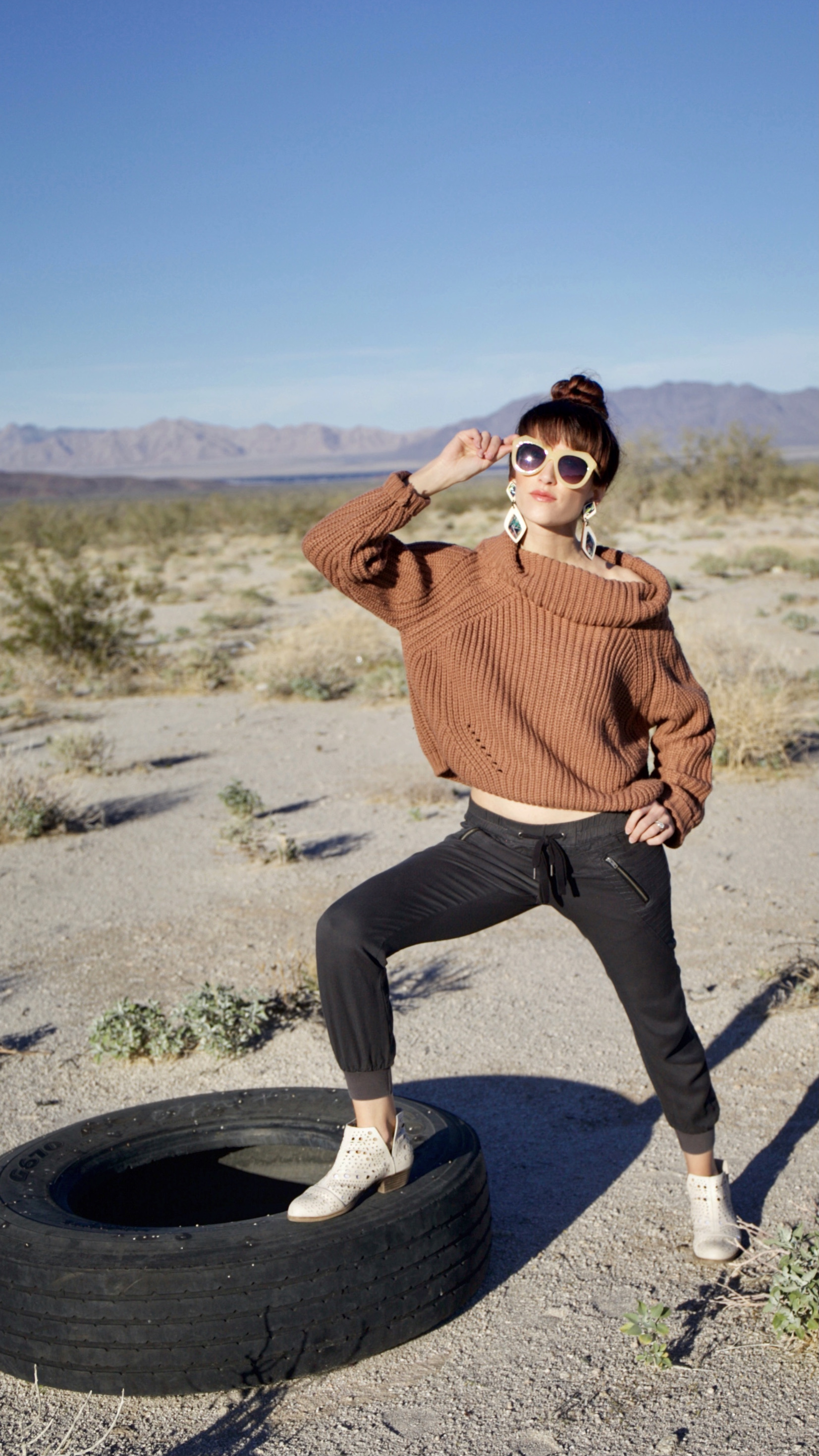 Alyssa Bird standing on an old tire in the desert in Arizona