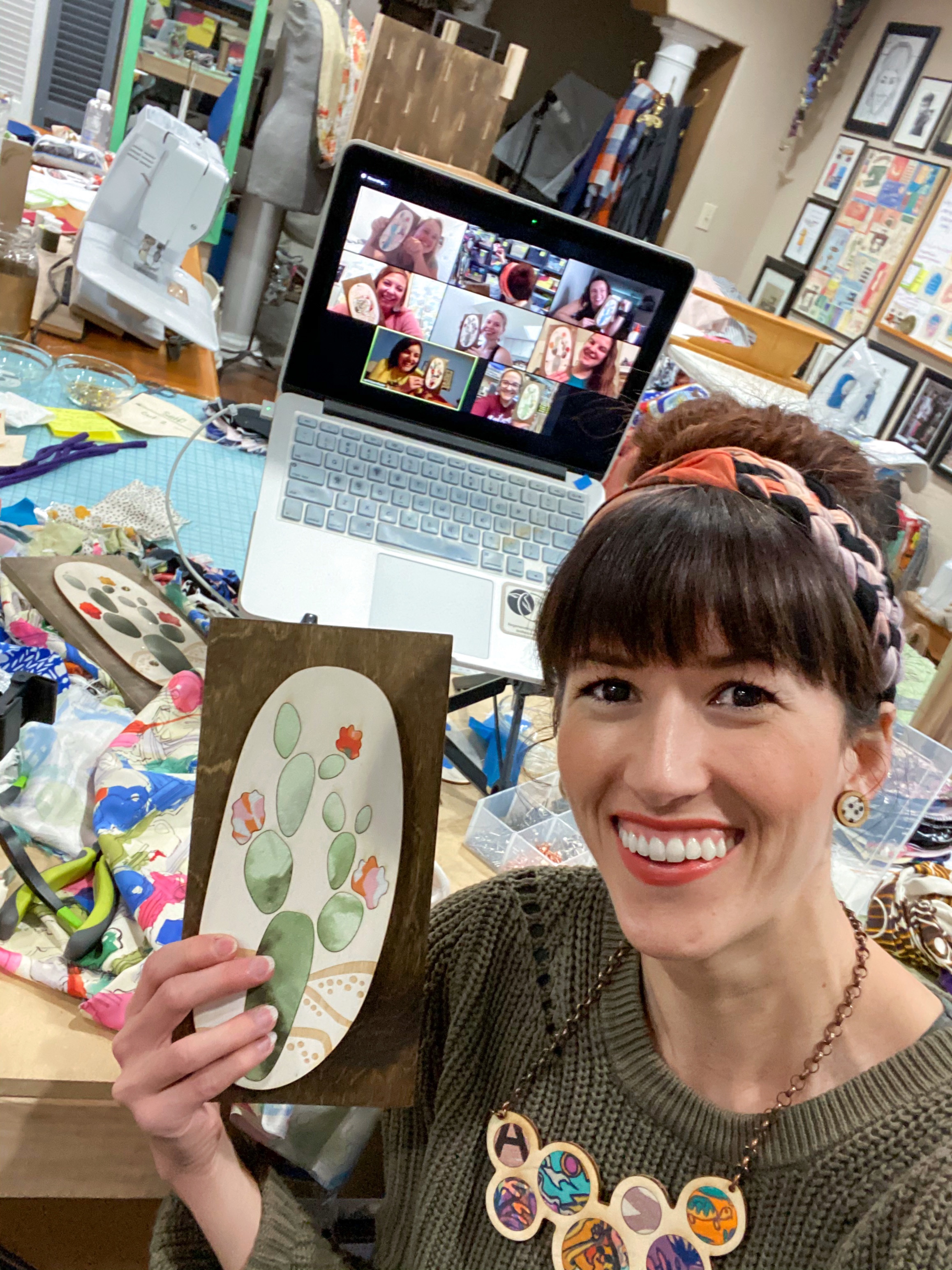 Alyssa Bird and a group of students on the computer doing a DIY Art workshop through zoom. Holding their textile and wood art they made