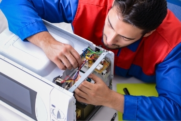 Man repairing a microwave