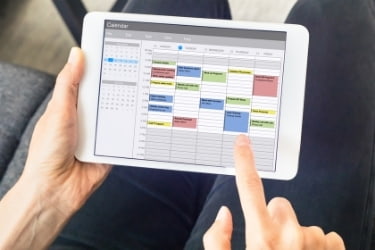 Person scheduling their time in a tablet