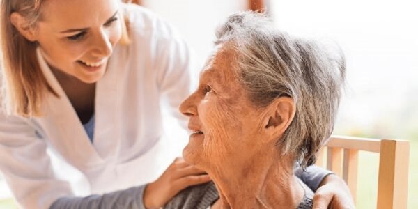 A doctor smiling and looking into the eyes of a patient, showing empathy.
