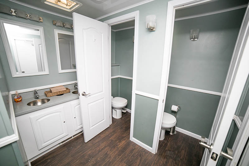 lady's side of a restroom trailer with two stalls and two sinks