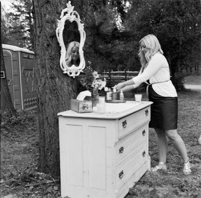outdoor bathroom sing with a mirror hanging on a tree