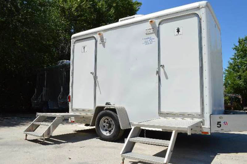 white bathroom trailer with two stalls