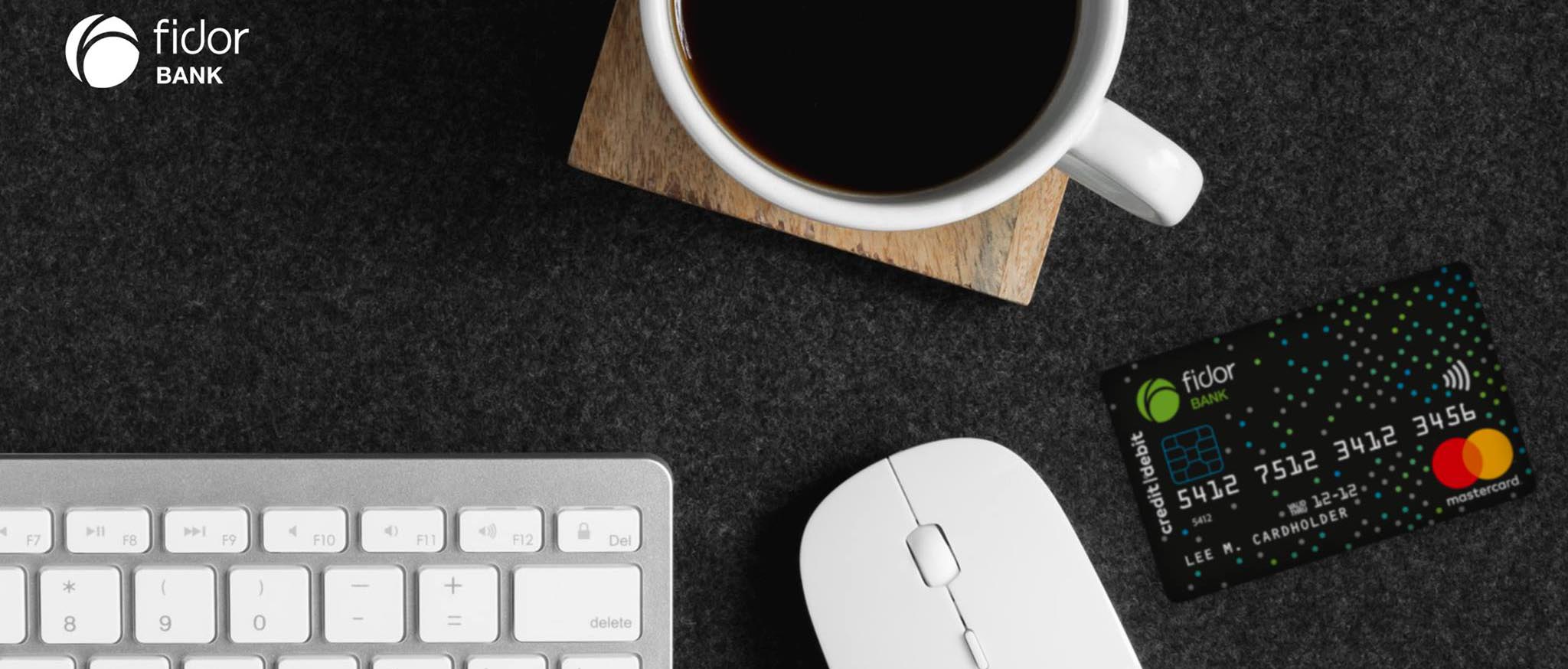 Tastatur, Maus, Tasse und Kreditkarte auf dunklem Hintergrund
