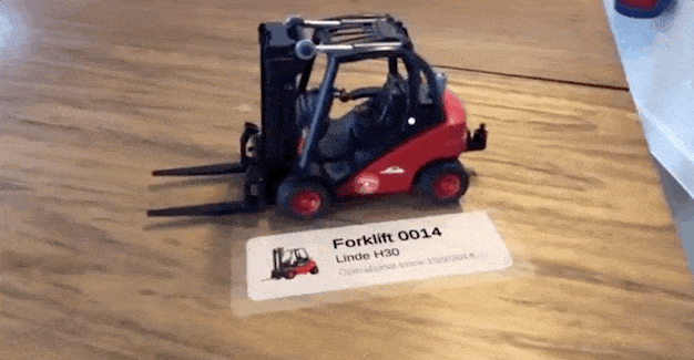 An AR miniature forklift being inspected on a table