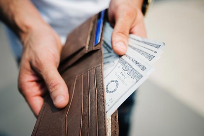 person opening wallet and paying too much for healthcare