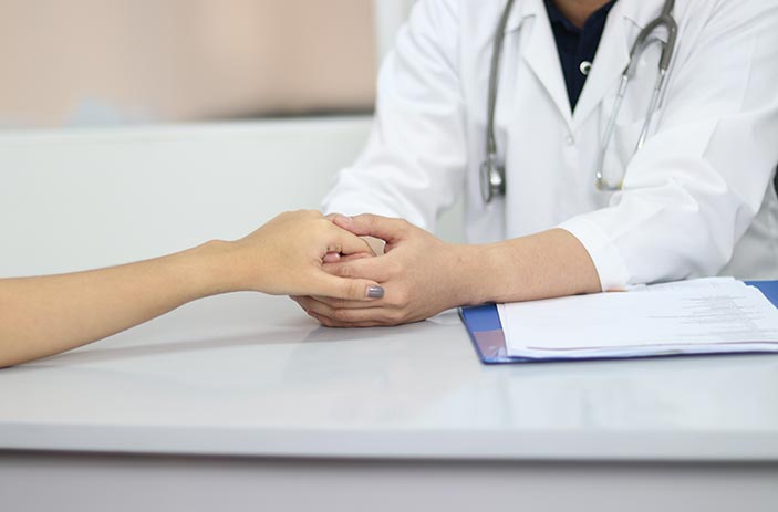 Family medicine physician holding patient's hand