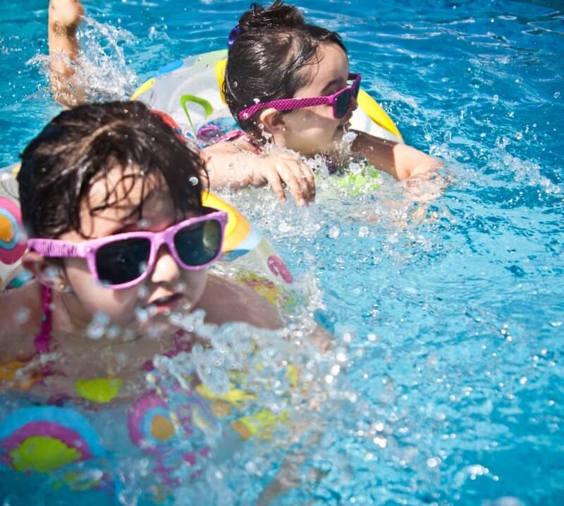 children playing in pool during summer