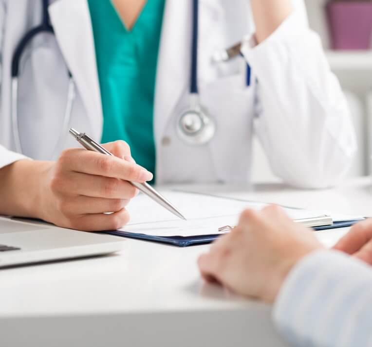 Doctor discussing test results on a clipboard with patient