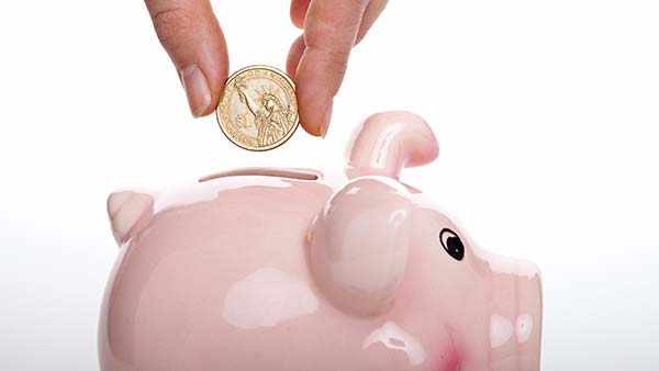 Saving money on healthcare dropping coin into piggy bank