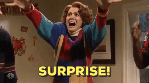 GIF of a woman yelling surprise with her arms in the air.