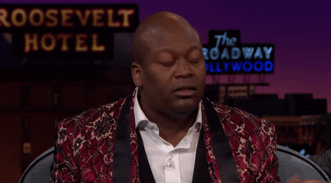 GIF of a person throwing their hands up looking very shocked.