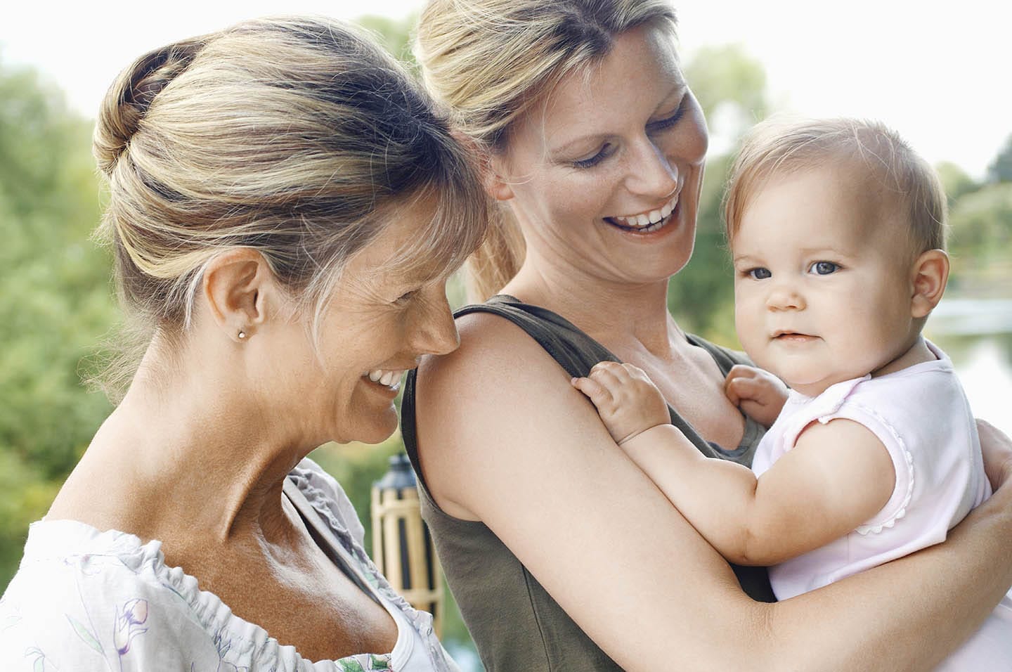 Two women smiling at a baby
