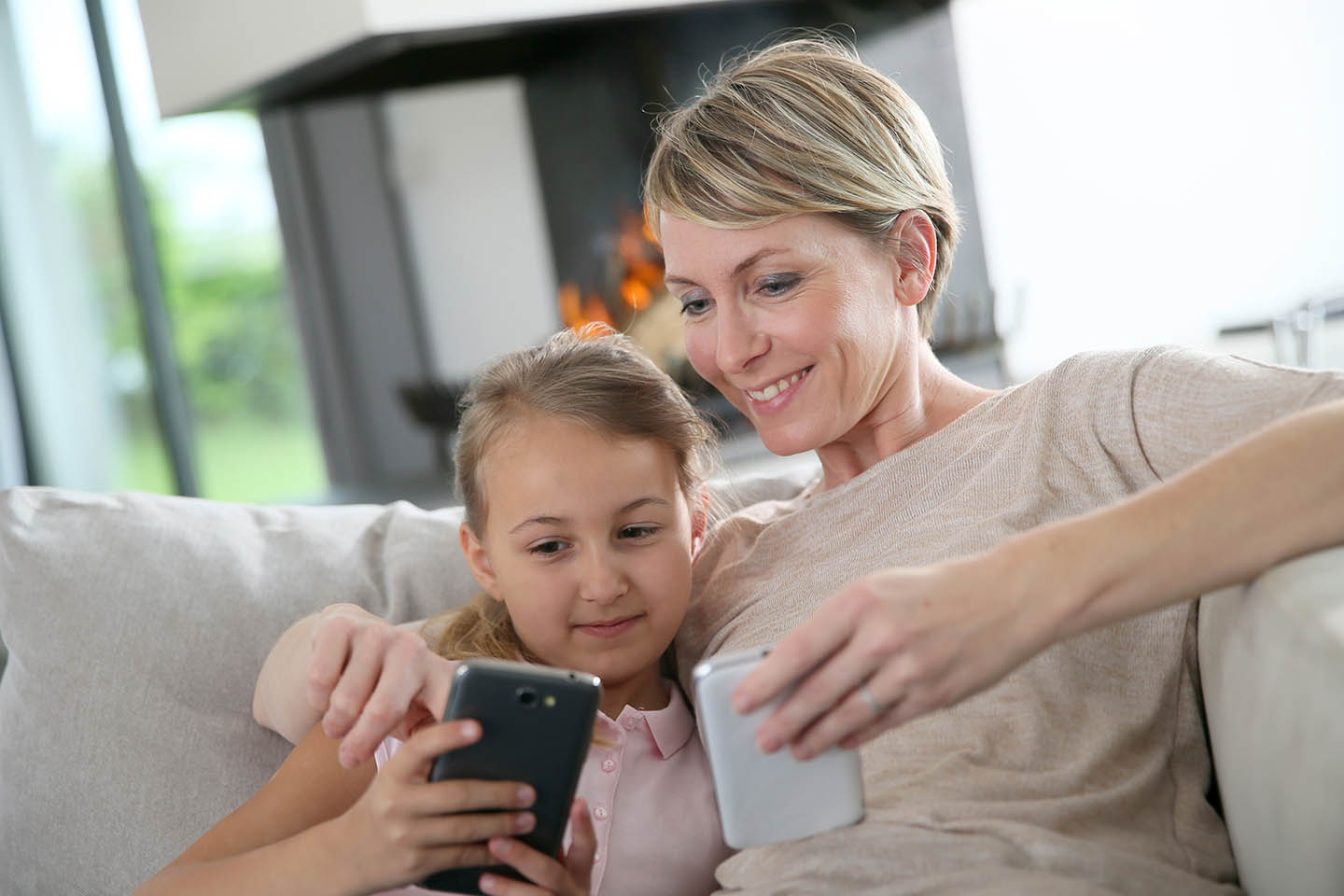 Mother and daughter smiling at smartphone
