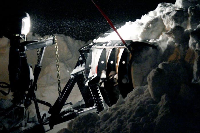 Photograph of clearing snow at night