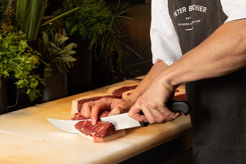 Butcher chopping meat for ready meal