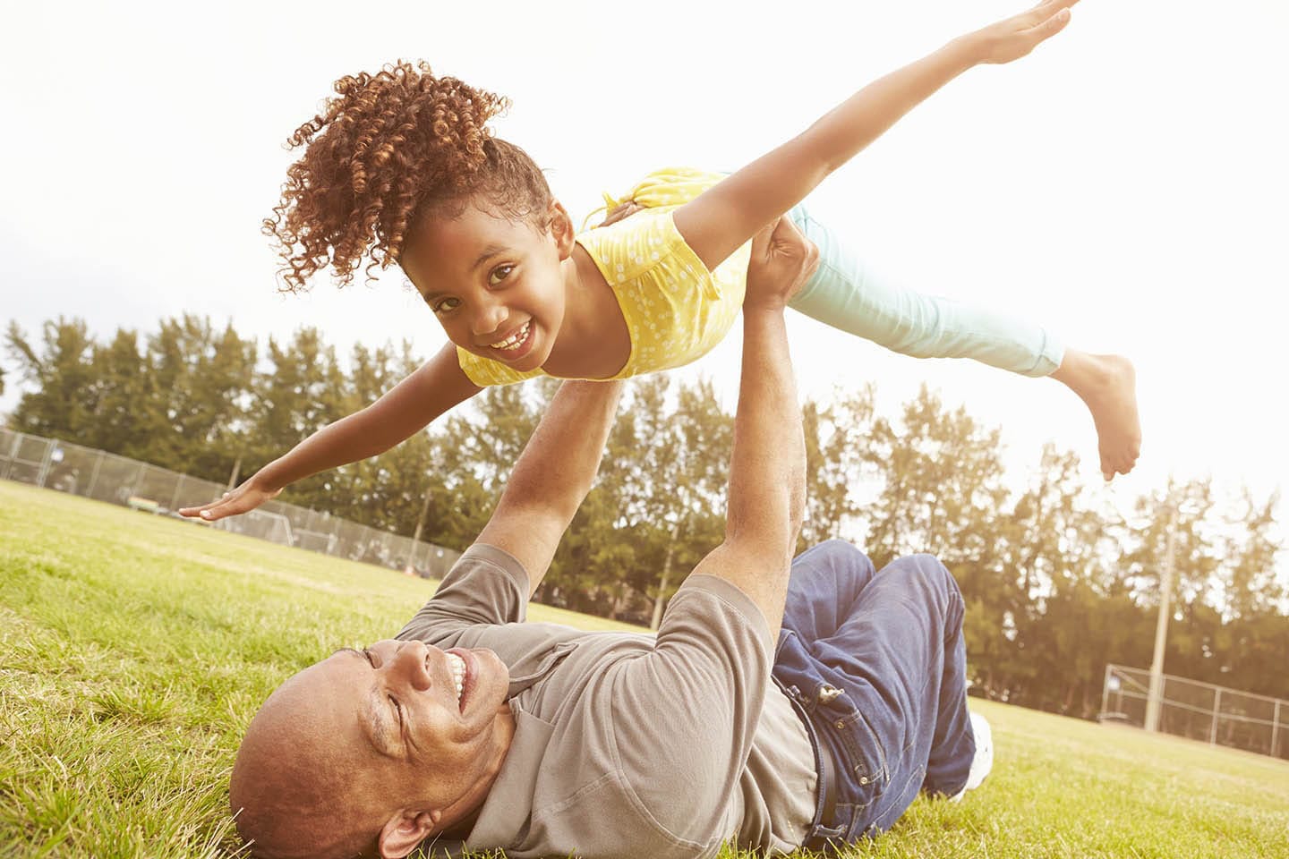 father holding up daughter