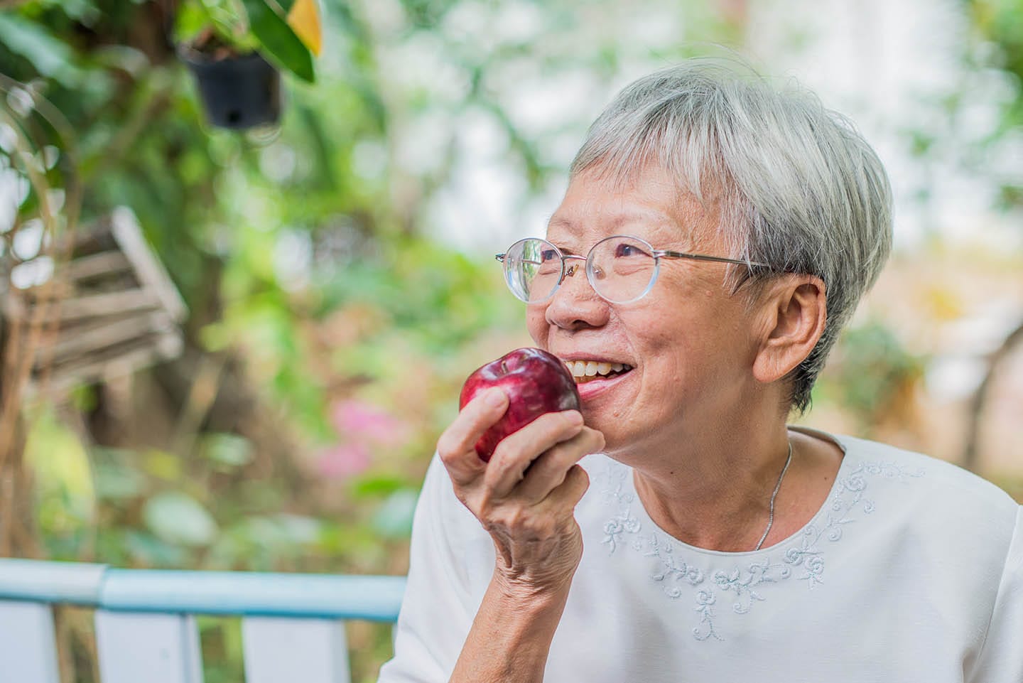 elderly woman eating apple