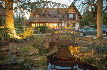 Maison dans la verdure avec un pont