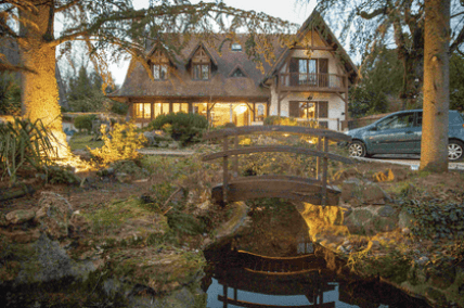 maison dans la verdure avec un pont