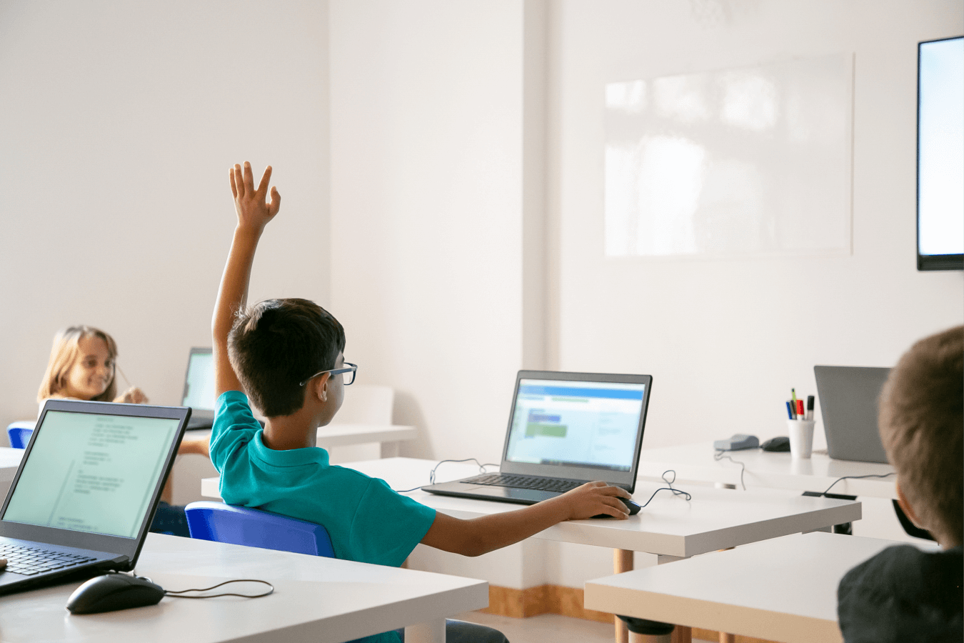 school boy raises hand in class for help