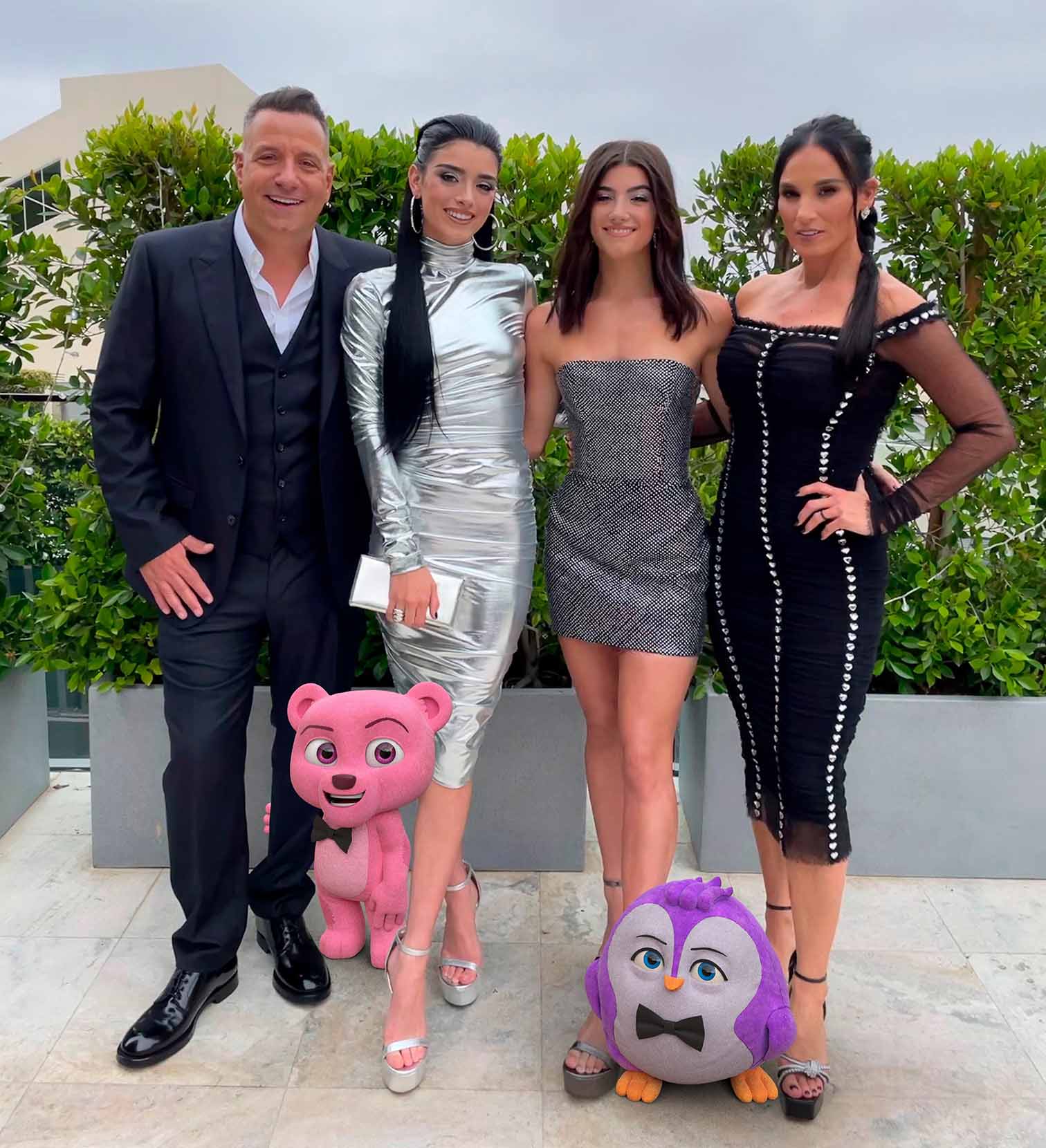 The D'Amelio family standing with Squeaky and Roy