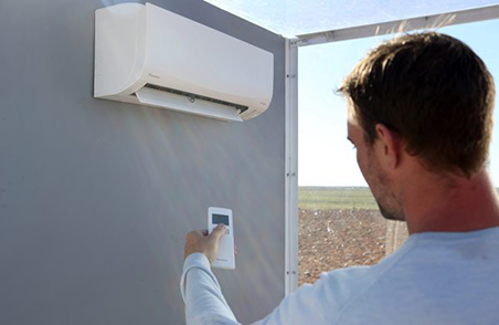 A man using a remote for an air conditioner