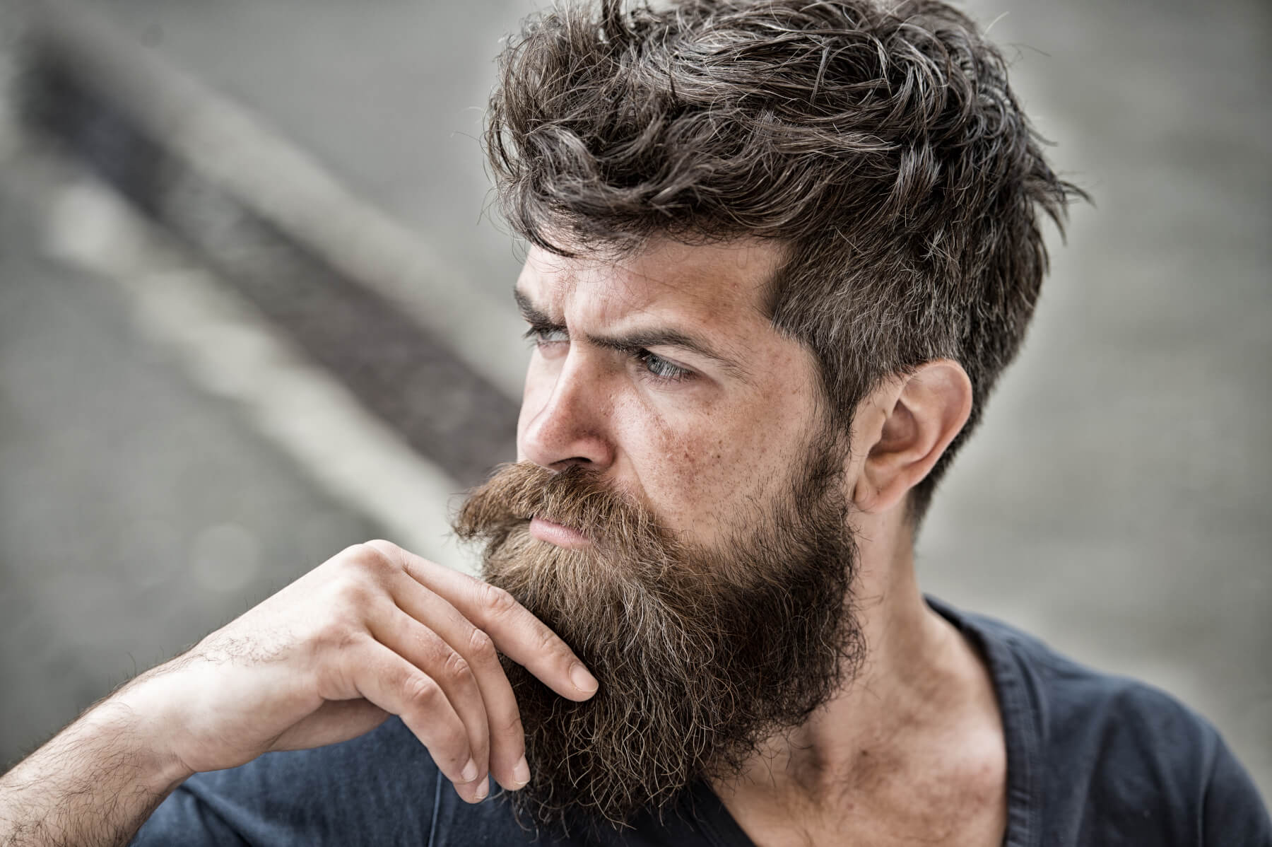 A man stroking his beard.
