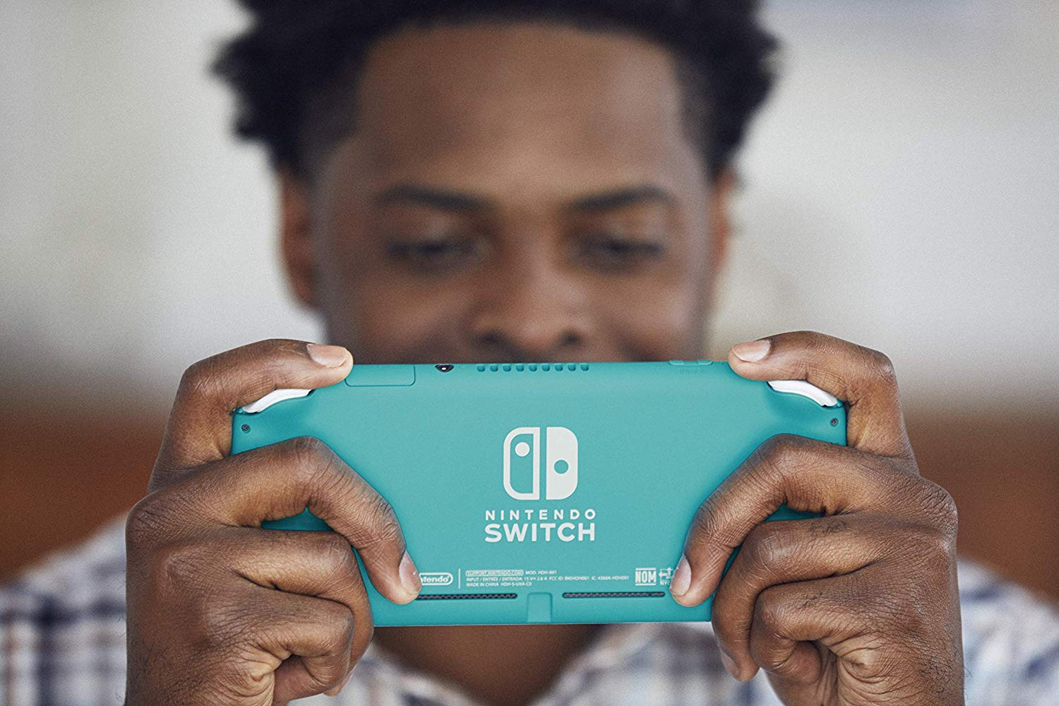 A man playing a Nintendo Switch Lite.