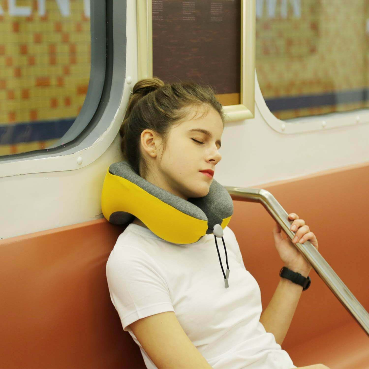 A person sleeping on a train with a neck pillow.