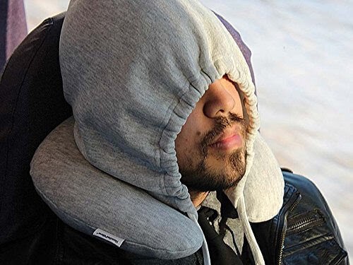 A man sleeping with travel pillow that as a hood.
