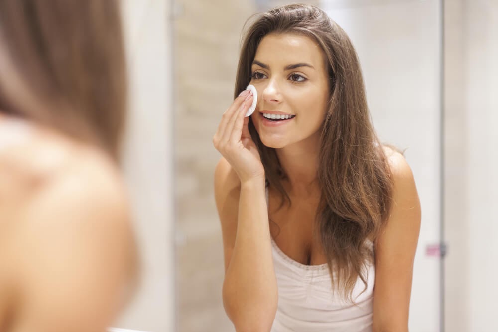 woman cleaning her face