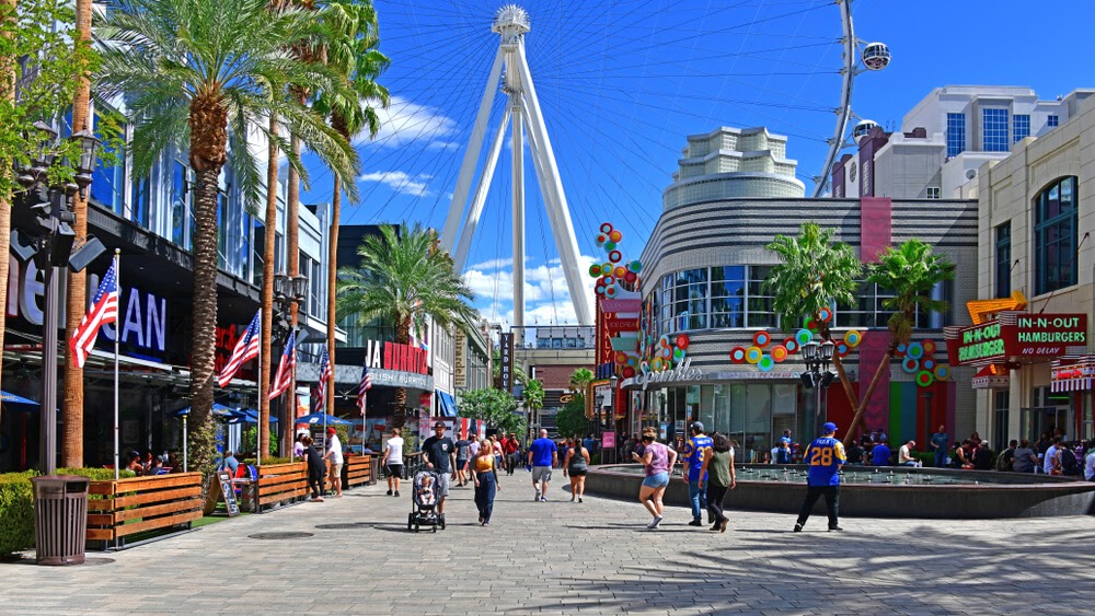 Promenade goers walk outside in the sunshine