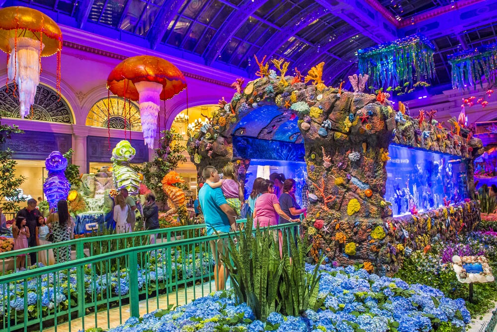 Families walking through brightly colored indoor aquarium