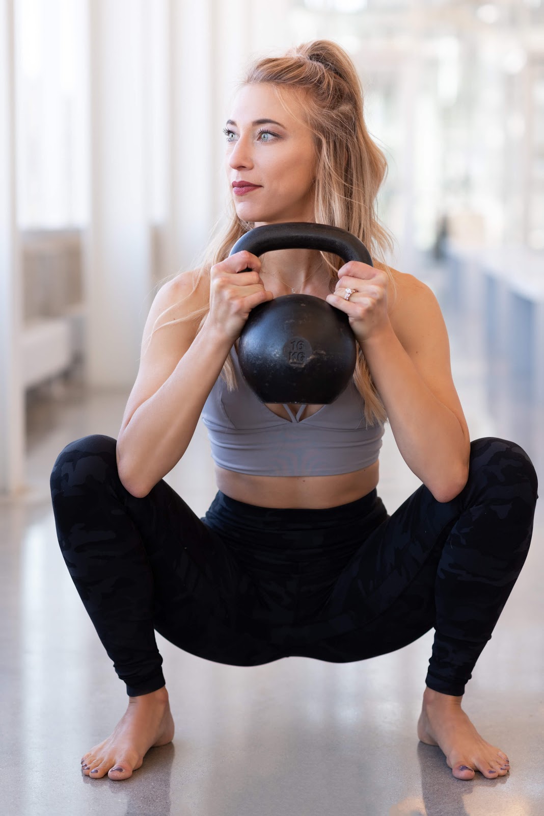 Woman performing goblet squat with a kettlebell