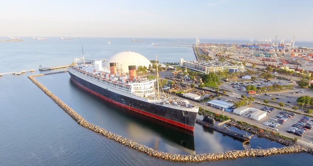 RMS Queen Mary. Large black and red boat docked in bay.