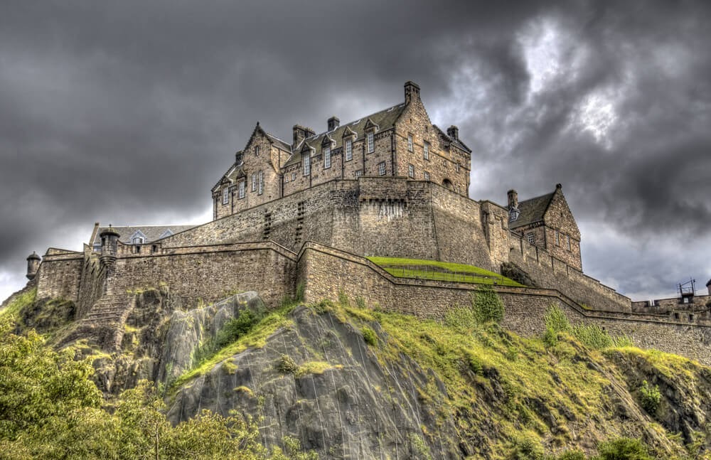 Edinburgh Castle in Scotland photographed from below against a dark grey sky.