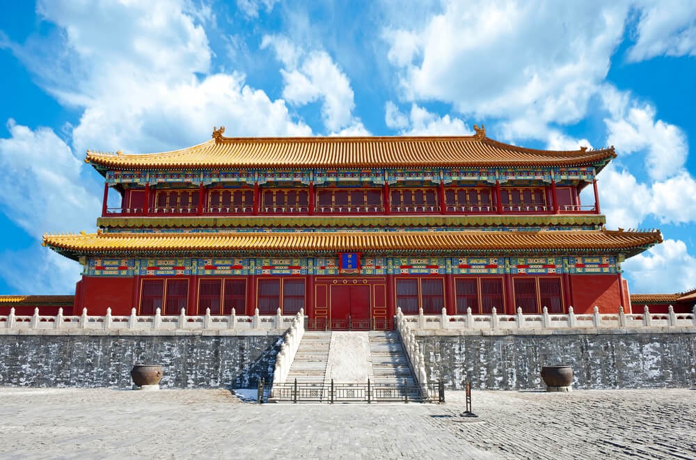 Beijing Forbidden City, China. Large red building with multicolor decoration and a gold roof.