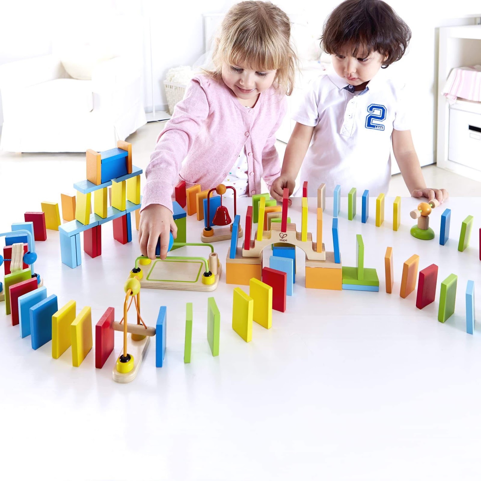 Two kids play with blocks and learning toys.
