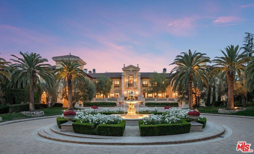 67 Beverly Park Court, a massive Hollywood mansion with a beautiful sunset in the background.