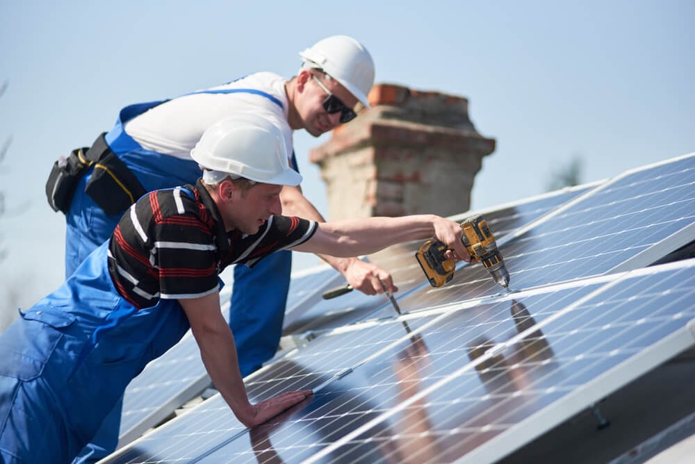 Two men installing solar panels