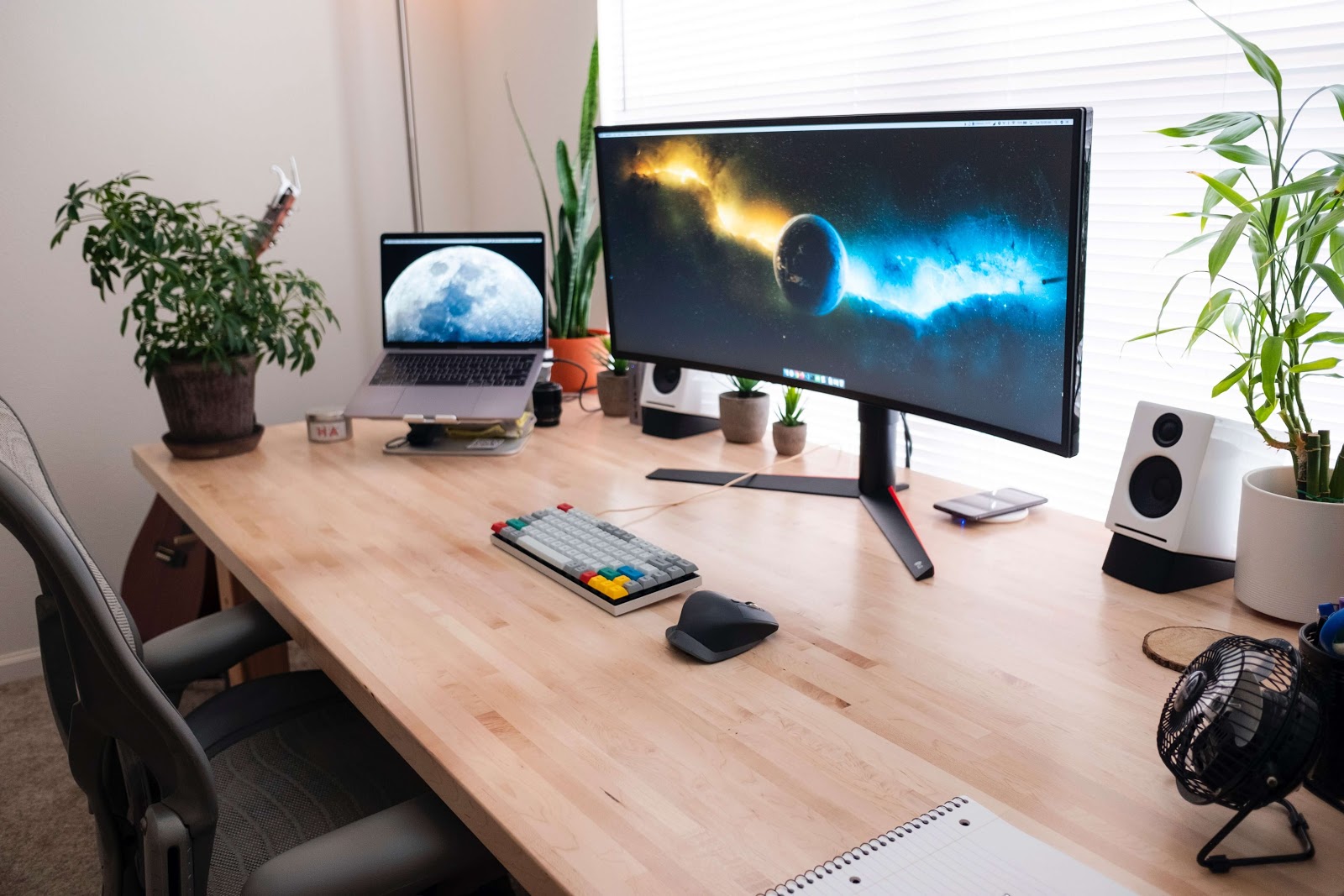 Large monitor with keyboard and laptop. Looks like a home office setup.